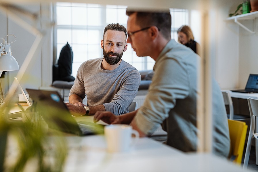 Twee collega's overleggen aan een bureau